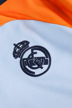 Traje de entrenamiento naranja y azul del Real Madrid 2025-26