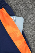 Traje de entrenamiento naranja y azul del Real Madrid 2025-26