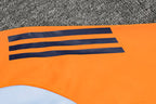 Traje de entrenamiento naranja y azul del Real Madrid 2025-26