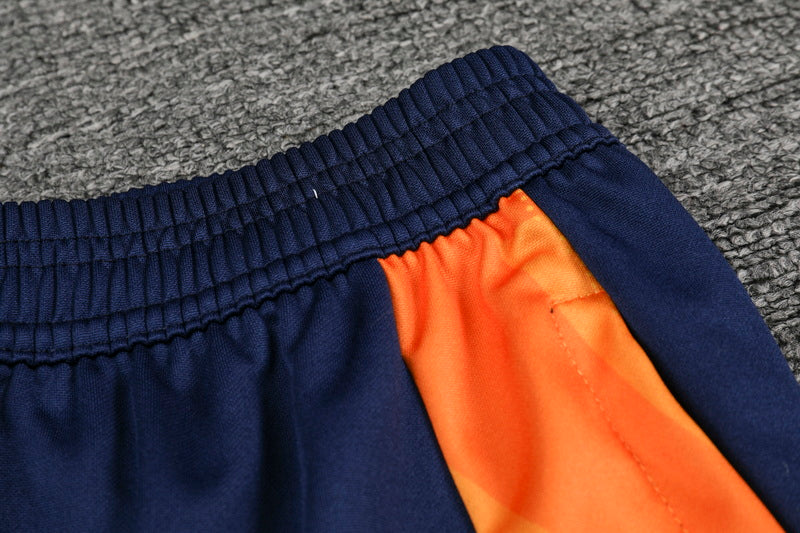 Traje de entrenamiento naranja y azul del Real Madrid 2025-26
